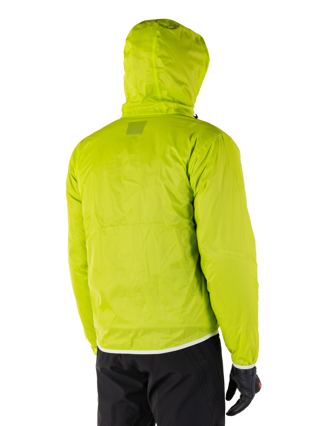 Alpinestars Mohobbs Wasserdichte Jacke, packbares Regenfutter in Lime Punch, Rückansicht der neongrünen wasserdichten Schicht mit Kapuze, getragen mit schwarzer Motorradhose und Handschuhen
