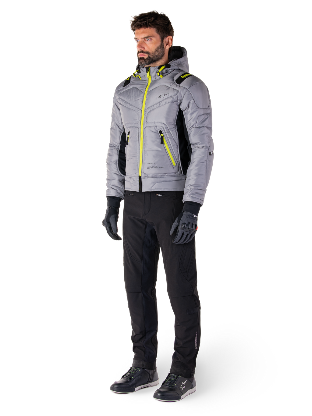 Alpinestars Mohobbs Wasserdichte Jacke in Lunar Gray und Lime Punch, gesteppte Motorradjacke im Bomber-Stil mit neonfarbenen Akzenten, getragen von einem Model mit schwarzer Fahrhose und Handschuhen, urbane Streetwear-inspirierte Schutzausrüstung