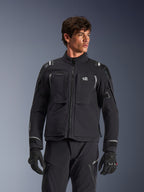 Alpinestars Andes Pro Drystar® XF Jacke, schwarz-dunkelgraue Motorrad-Adventure-Touringjacke, getragen mit passender Hose und Handschuhen, technische laminierte Schalenkonstruktion, ALL TERRA Logo auf der Brust, reflektierende Details, verstellbare Ärmelbündchen