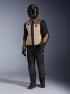 Alpinestars Andes Pro Drystar® XF Jacket in Walnut Aluminum, adventure motorcycle jacket worn with matching black pants, a black adventure helmet with goggles, and black boots, featuring tan and black panels with red accents.