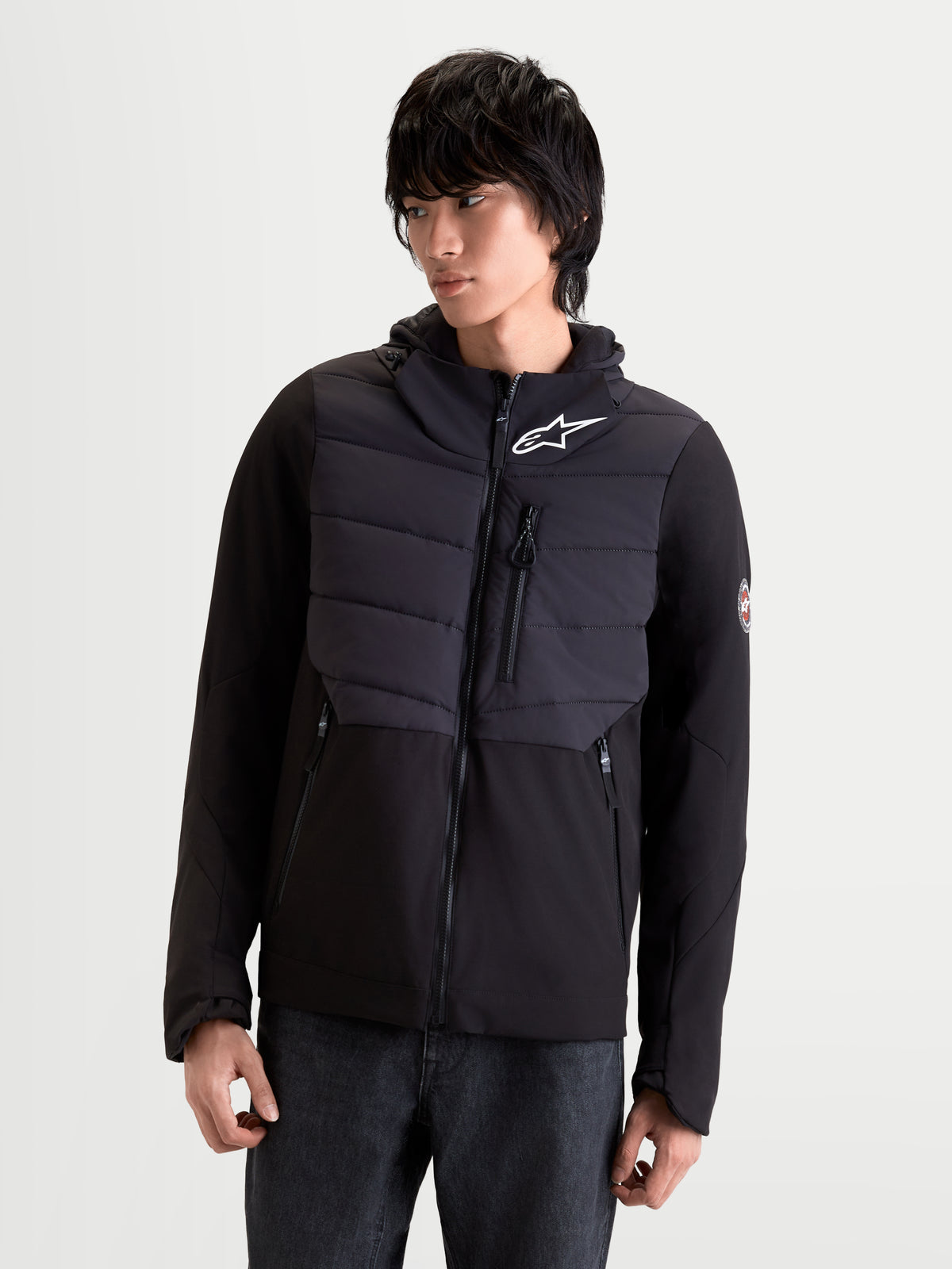 Alpinestars Therma Tech Wp Jacke, urbane Motorradjacke für Herren in Schwarz, Vorderansicht an einem Model, das die isolierte Textiljacke mit Kapuze trägt