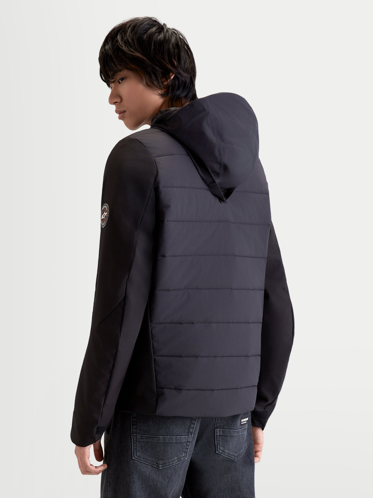 Alpinestars Therma Tech Wp Jacke, urbane Herren-Motorradjacke in Schwarz, Rückansicht des Modells mit integriertem Kapuzensystem und Steppkonstruktion