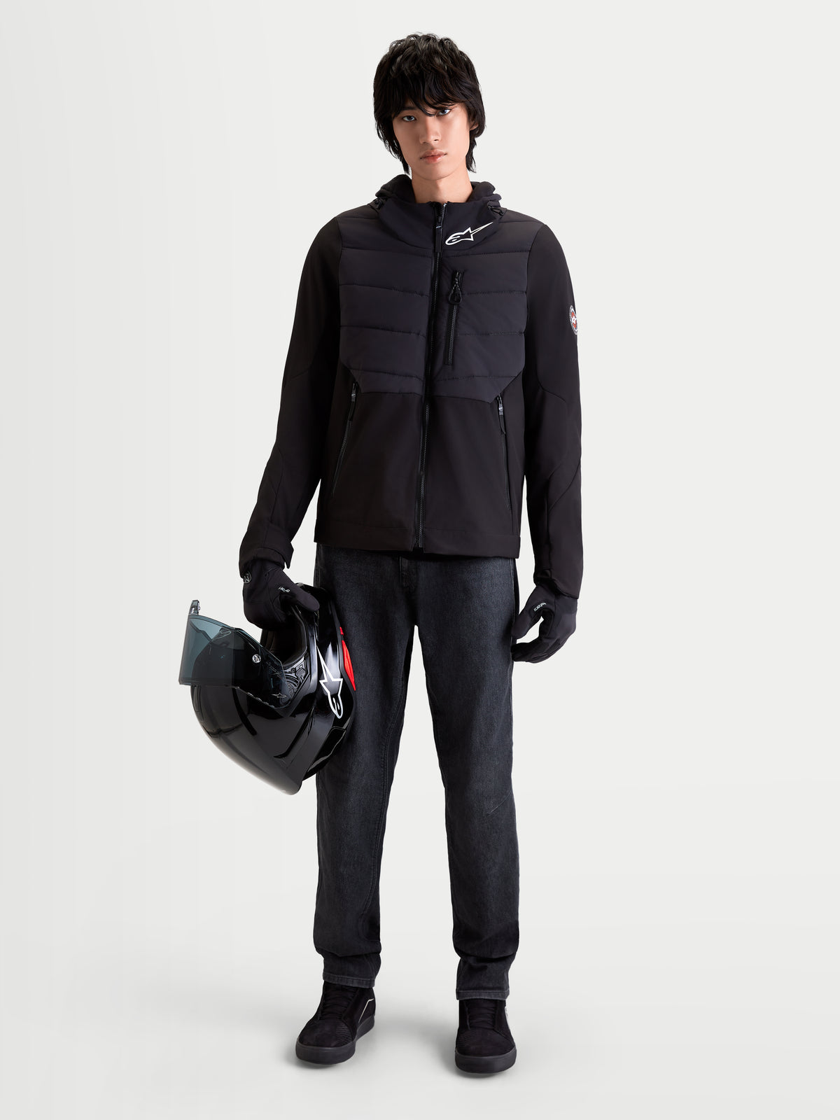 Alpinestars Therma Tech Wp Jacke, urbane Herren-Motorradjacke in Schwarz, Vorderansicht an einem Model mit passenden Handschuhen und Helm, mit sonic-welded Daunen-Konstruktion und Softshell-Textil