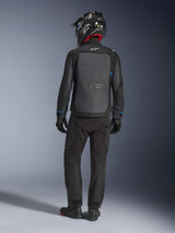 Alpinestars Cusco Drystar® Jacke, Schwarz und Dunkelgrau, Rückansicht eines Fahrers in kompletter Adventure-Touring-Ausrüstung, großes graues Rückenpanel mit Alpinestars-Logo, blaue Ärmelakzente, getragen mit passender schwarzer Hose und Helm.