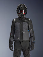Alpinestars Cusco Drystar® Jacket, Black and Deep Gray, motorcycle adventure touring jacket worn with matching black technical pants and a dual-sport helmet, featuring a two-tone design with ripstop panels and Alpinestars branding