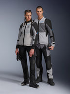 Man and woman wearing Alpinestars Stella ST-2 Air Jackets and matching technical pants, Ice Gray and Black colorway with blue accents, featuring mesh ventilation and 'ALPINESTARS EXPLORATION EQUIPMENT' branding, studio couple shot