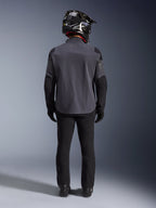 Alpinestars Maxdura Drystar®XF Laminated Armored Shell, Deep Gray Black, Ganzkörper-Rückansicht, technische Adventure-Jacke mit verstärkten Einsätzen, getragen mit schwarzer Motorradhose, Handschuhen und einem schwarz-weißen Offroad-Helm, abgestimmtes Dual-Sport-Ausrüstungsset