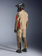 Adventure-Fahrer in der Rückansicht mit der Alpinestars Maxdura Drystar®XF Laminated Armored Shell in Aluminum Walnut Rust Brown, kombiniert mit passender Motorradhose, schwarzem Offroad-Helm und schwarzen Stiefeln, komplettes technisches Touren-Outfit.