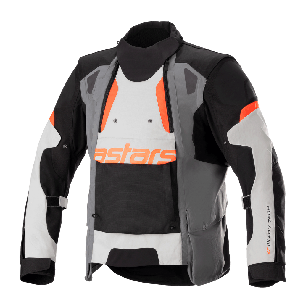 Alpinestars Halo Drystar® Jacke, Motorrad-Adventure-Touring-Jacke, Dunkelgrau, Eisgrau und Schwarz mit orangefarbenen Akzenten, asymmetrischer Belüftungseinsatz vorne, orangefarbenes Astars-Branding, verstellbare Ärmelriemen, hoher Kragen, schützende Textilausrüstung für Ganzjahres-Abenteuerfahrten