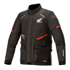 Honda Andes V3 Drystar Jacke, Motorrad-Tourenjacke, Schwarz mit roten Akzenten, Vorderansicht mit großen Cargotaschen und verstellbaren Riemen, technische Textilkonstruktion mit Honda-Flügel und Alpinestars-Logos, Adventure-inspiriertes Design
