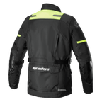 Alpinestars Andes V3 Drystar® Jacke, Rückansicht der Adventure-Motorradjacke in Schwarz und Gelb Fluo, mit einer großen Utility-Tasche am unteren Rücken inklusive Alpinestars-Logo, High-Visibility-Schulterpaneelen und verstellbaren Taillengurten.