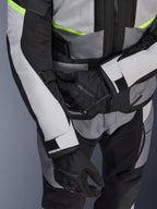 Alpinestars Andes Air Drystar® Jacket, Motorcycle Touring Jacket, Ice Gray and Dark Gray with Neon Yellow accents, close-up showing mesh panels and adjustment straps, worn with black Alpinestars gloves