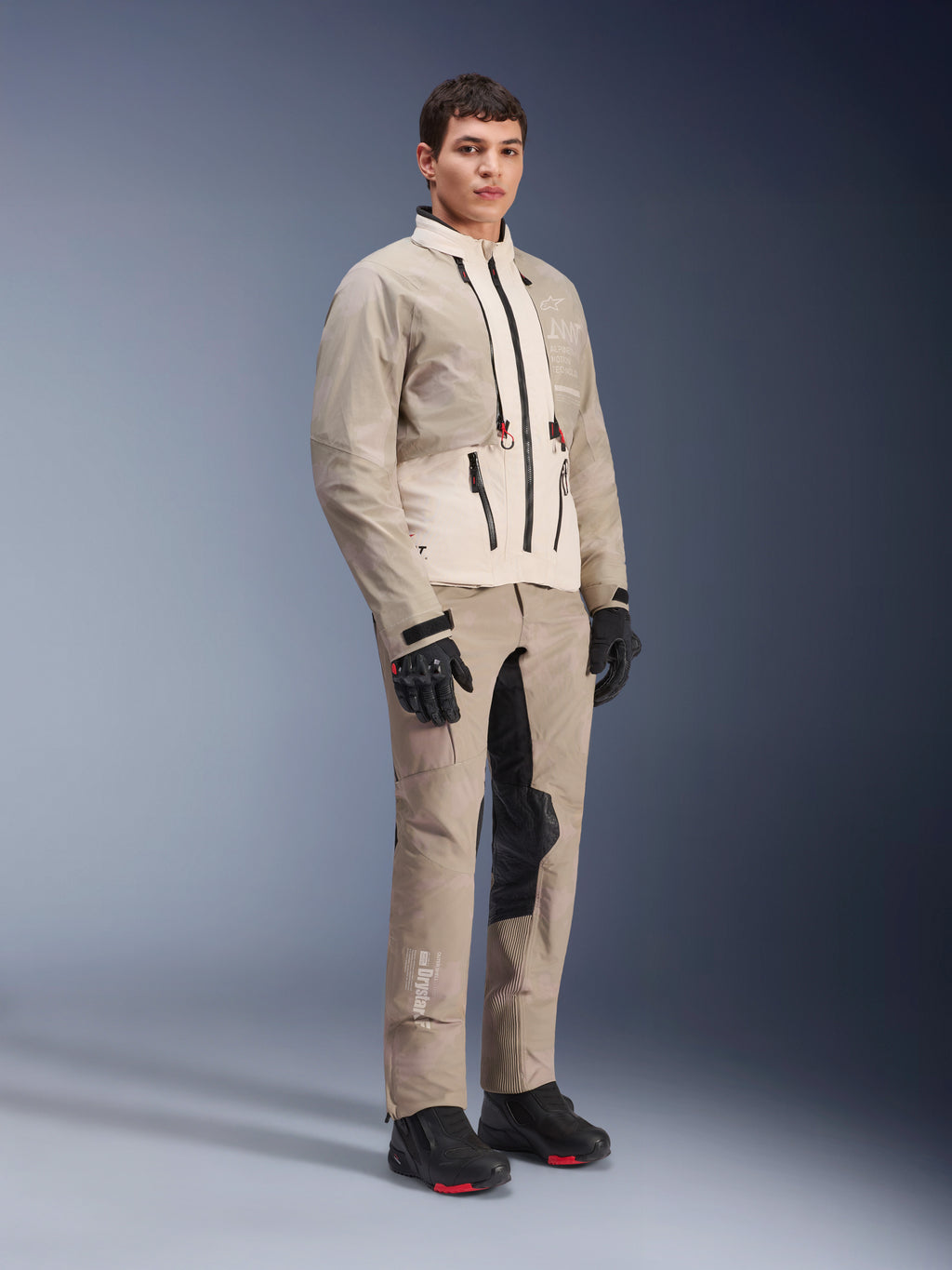 Alpinestars AMT-10LAB Drystar® XF Jacke, Adventure-Motorradjacke, White Sand Aluminum Camo, getragen mit passender Adventure-Hose, schwarzen Motorradhandschuhen und Stiefeln, Ganzkörper-Studioaufnahme, Mehrjahreszeiten-Schutzausrüstung