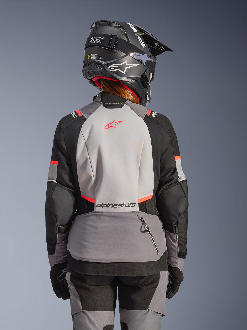 Alpinestars Stella Andes V4 Drystar® Jacke, Damen-Adventure-Motorradjacke, Grau, Schwarz und Koralle Fluo, wasserdichte Touring-Bekleidung, Rückansicht am Model.