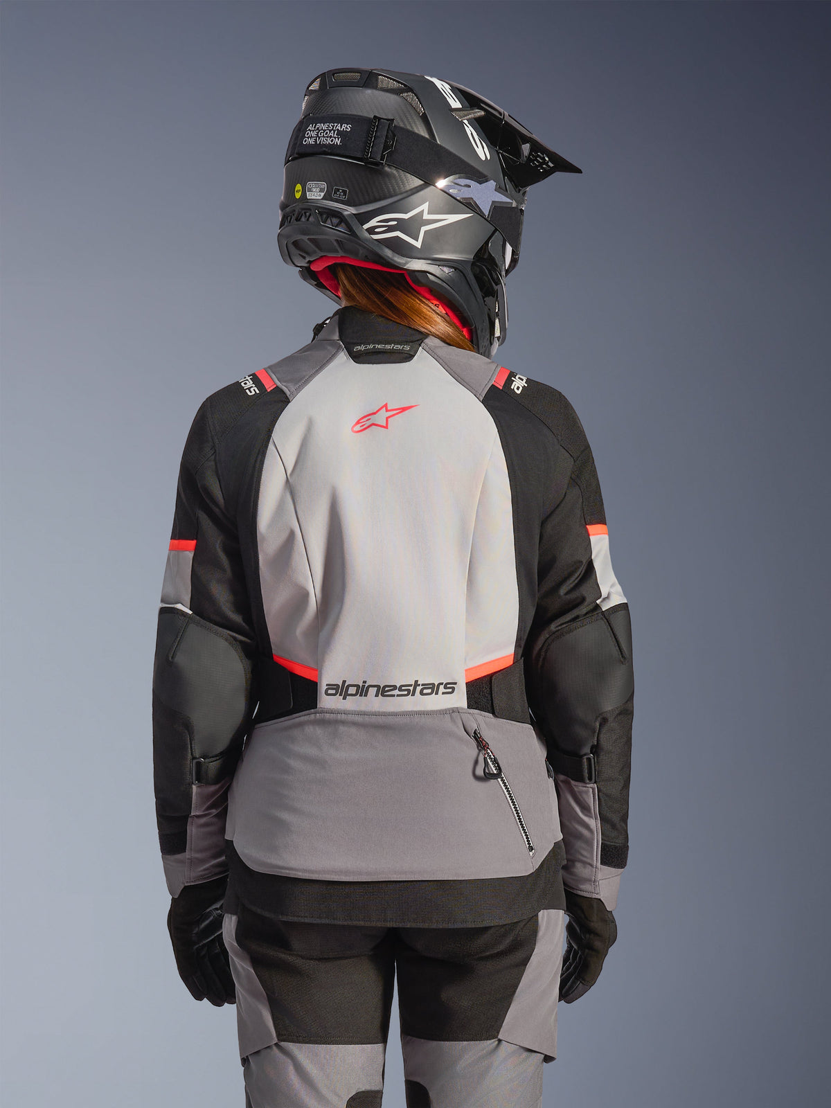 Alpinestars Stella Andes V4 Drystar® Jacke, Damen-Adventure-Motorradjacke, Grau, Schwarz und Koralle Fluo, wasserdichte Touring-Bekleidung, Rückansicht am Model.