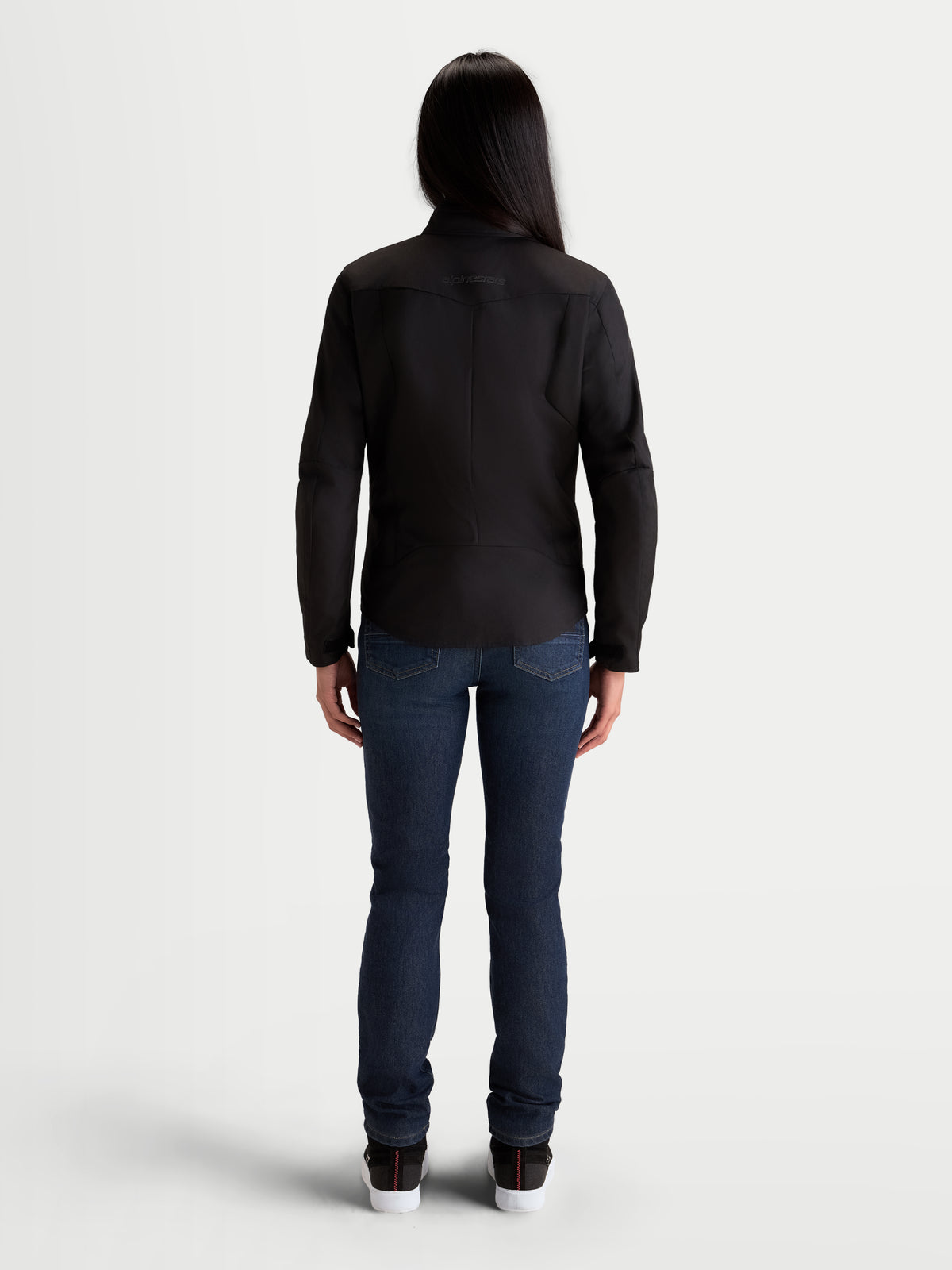Alpinestars Stella C 1 Waterproof Jacke, Damen-Motorradjacke in Schwarz, Rückansicht mit ergonomischer 3D-Rückenkonstruktion und wasserdichter Polyfabric-Außenschicht, getragen von einem weiblichen Model.