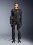 Alpinestars Stella ST-2 Air Jacket, Black, full-body studio view of a female rider wearing matching black motorcycle pants and gloves, featuring high-flow mesh panels, red logo details, and a modern touring design
