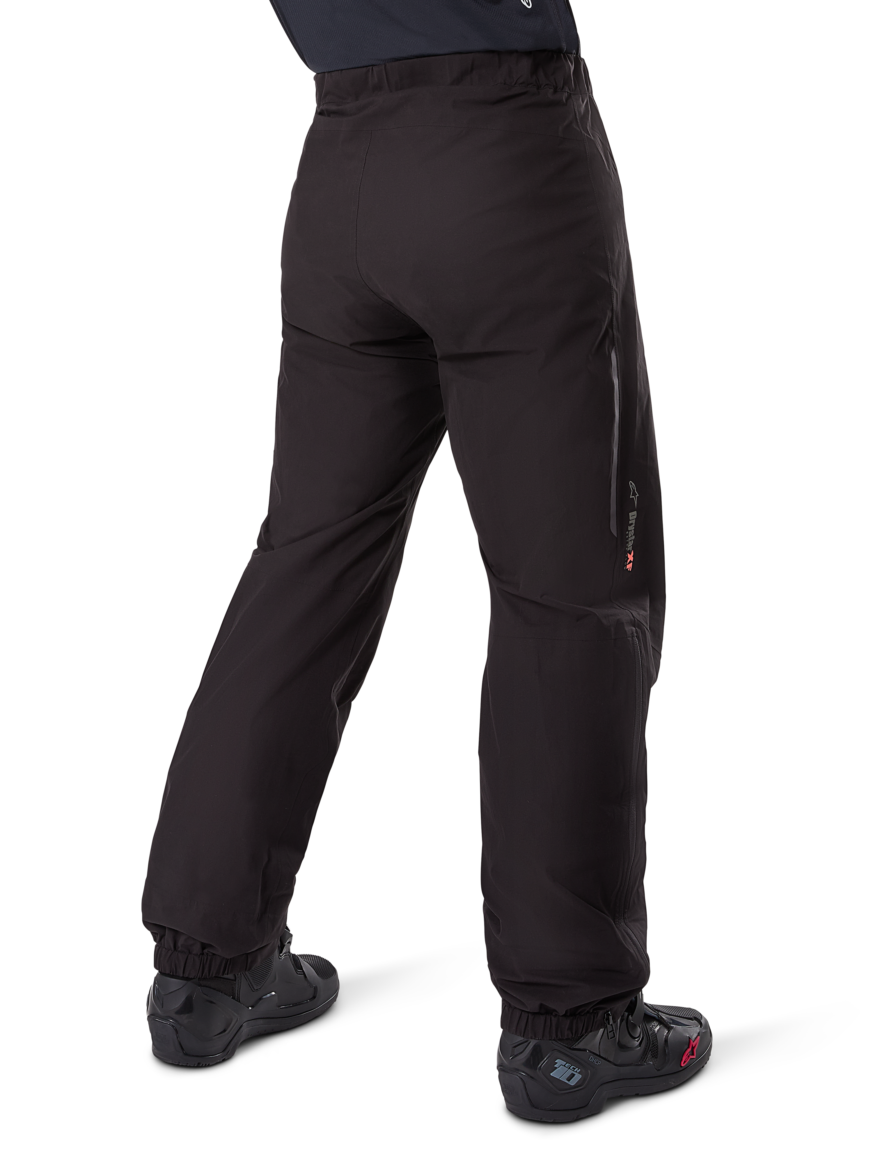 Alpinestars Amt-8 Stretch Drystar® XF Pant Liner, Black, rear view showing the waterproof liner worn over black motorcycle boots, featuring Drystar XF branding on the lower leg, elasticated ankle cuffs, and lightweight stretch material for adventure touring.
