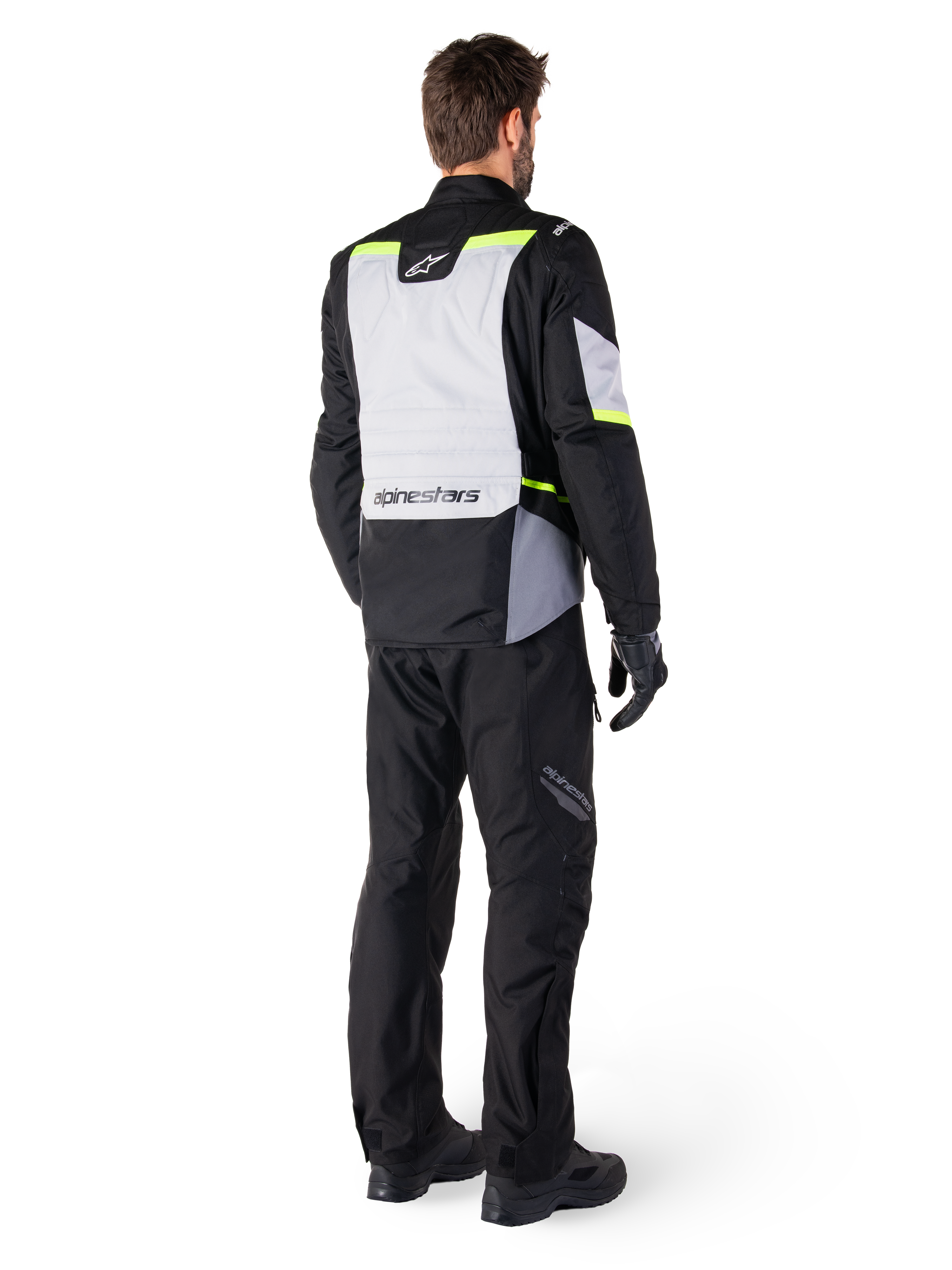 Alpinestars ST-1 Waterproof Pants, Black, rear view on a rider paired with a matching adventure touring jacket featuring gray and fluorescent yellow accents, worn with black boots and gloves, coordinated outfit for all-weather road and adventure riding