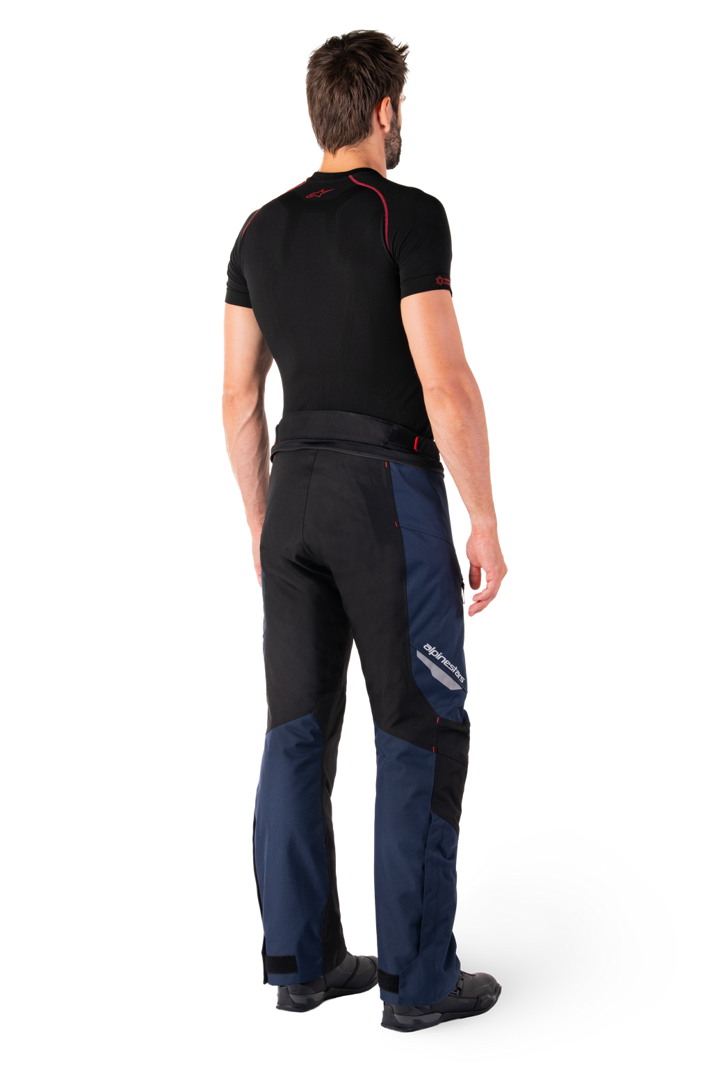 Alpinestars St-1 Waterproof Pants, Adventure Touring Pants, Dark Blue Black and Bright Red, rear side view worn with a black short-sleeved base layer and black riding boots, featuring a streamlined design with reflective branding and red accents