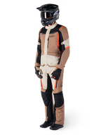 Rider wearing Alpinestars ST-1 Waterproof adventure touring suit, Dark Khaki Sand and Black jacket and pants with Red Fluo accents, black helmet and gloves, showcasing a complete waterproof outfit for all-weather motorcycle riding