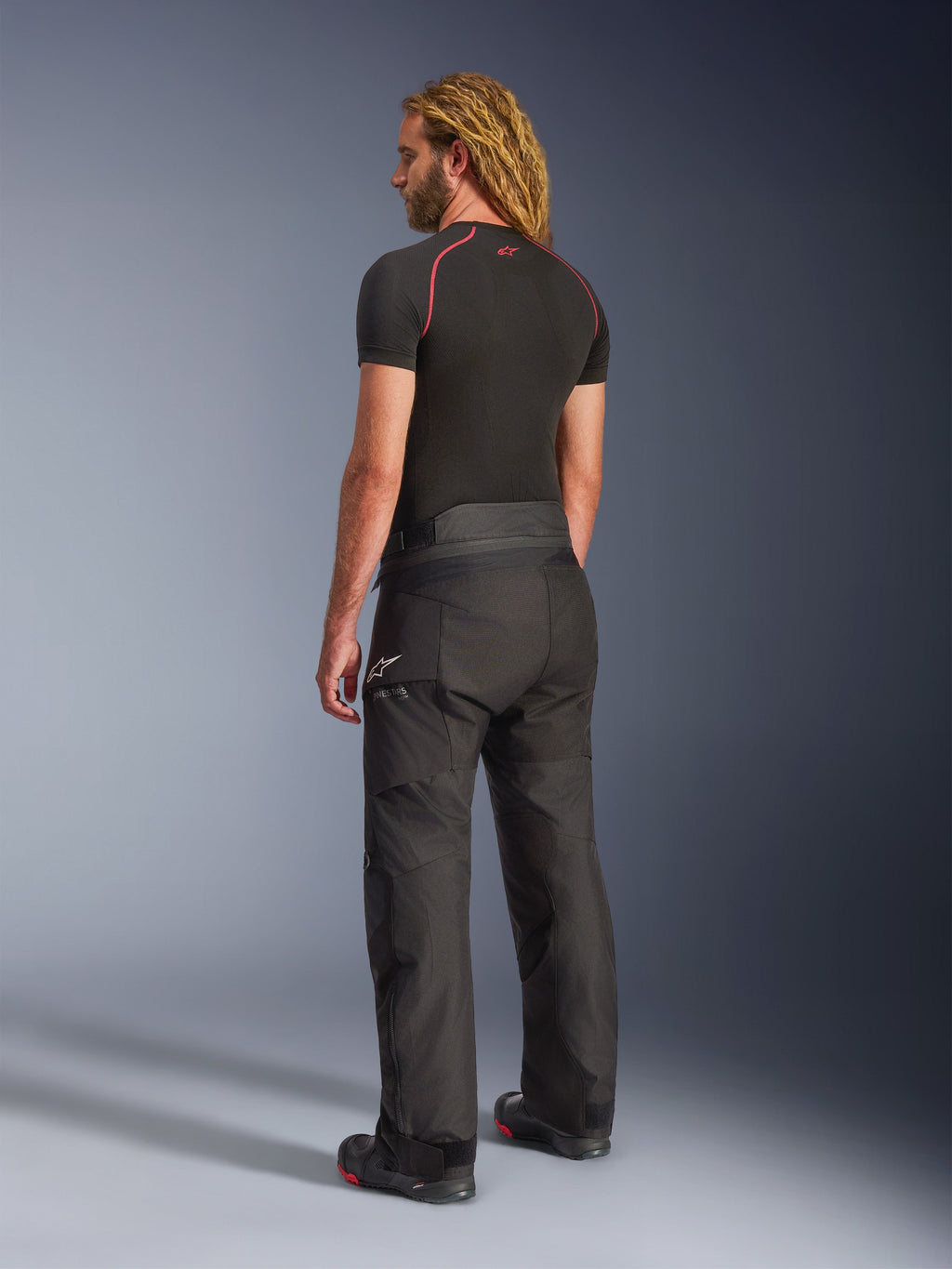 Alpinestars Andes V4 Drystar® Pants - Long, Adventure Motorcycle Pants, Black, rear three-quarter view on model, durable textile design with reinforced seat and knee panels, featuring Alpinestars star logo, worn with black base layer and riding boots
