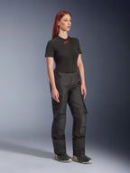 Alpinestars Stella Andes V4 Drystar® Hose, Damen-Motorradhose, Schwarz, getragen mit einem schwarzen Kurzarm-T-Shirt mit rotem Logo und technischen Schuhen, Adventure-Touring-Design mit verstärkten Einsätzen und Belüftungsreißverschlüssen, Dreiviertelansicht in voller Länge