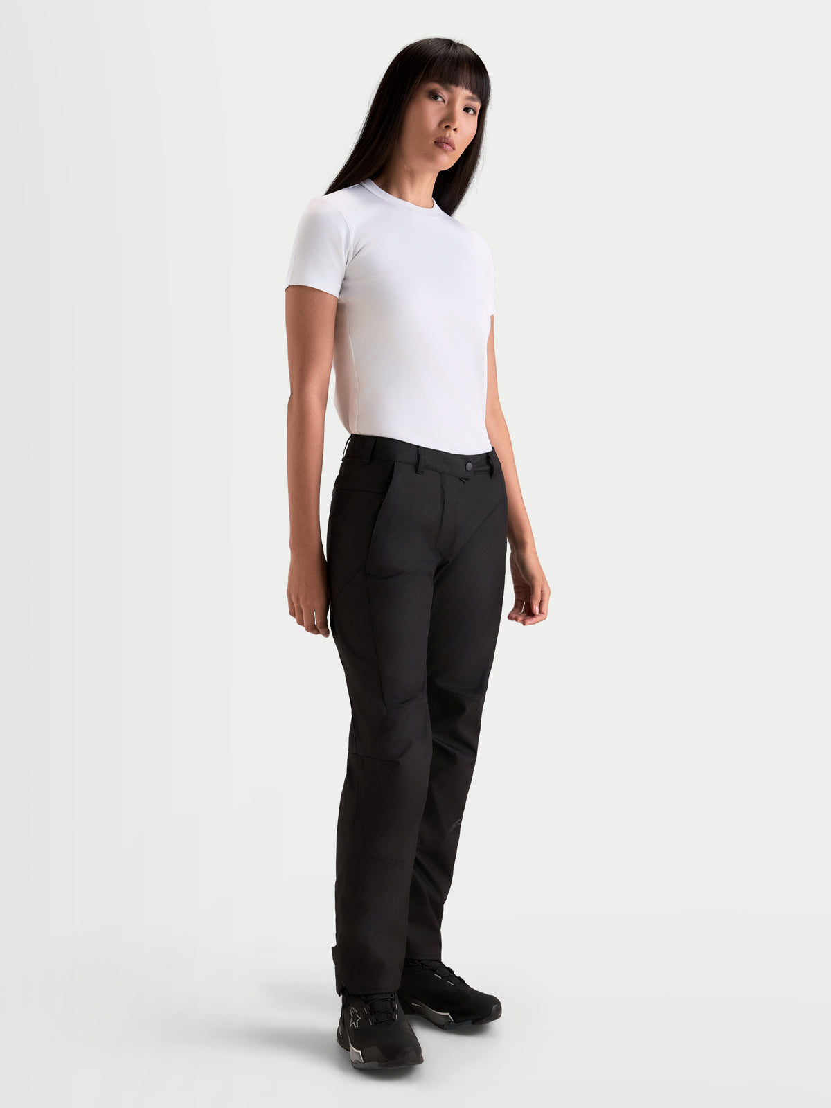 Alpinestars Stella C 1 Waterproof Hose, urbane Damen-Motorradhose in Schwarz, gerade geschnittene Textilkonstruktion, getragen von einem Model mit weißem T-Shirt, Ausrüstung für die kalte Jahreszeit