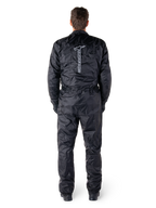 Alpinestars Hurricane Rain V2 Anzug, schwarzer einteiliger wasserdichter Motorrad-Regenanzug, Rückansicht mit großem vertikalem Alpinestars-Schriftzug und Logo, leichtes Gewebe mit elastischem Bund und Bündchen, konzipiert für Schutz bei nassem Wetter.