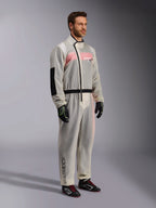 Alpinestars Kart Rain Suit, klarer wasserdichter Kart-Überanzug, halbtransparentes Material mit rosa-weißem Rennanzug darunter, schwarzer asymmetrischer Reißverschluss, verstärkter Ellbogenbesatz, schwarzer Taillenbund, schwarze Kart-Handschuhe und Rennschuhe