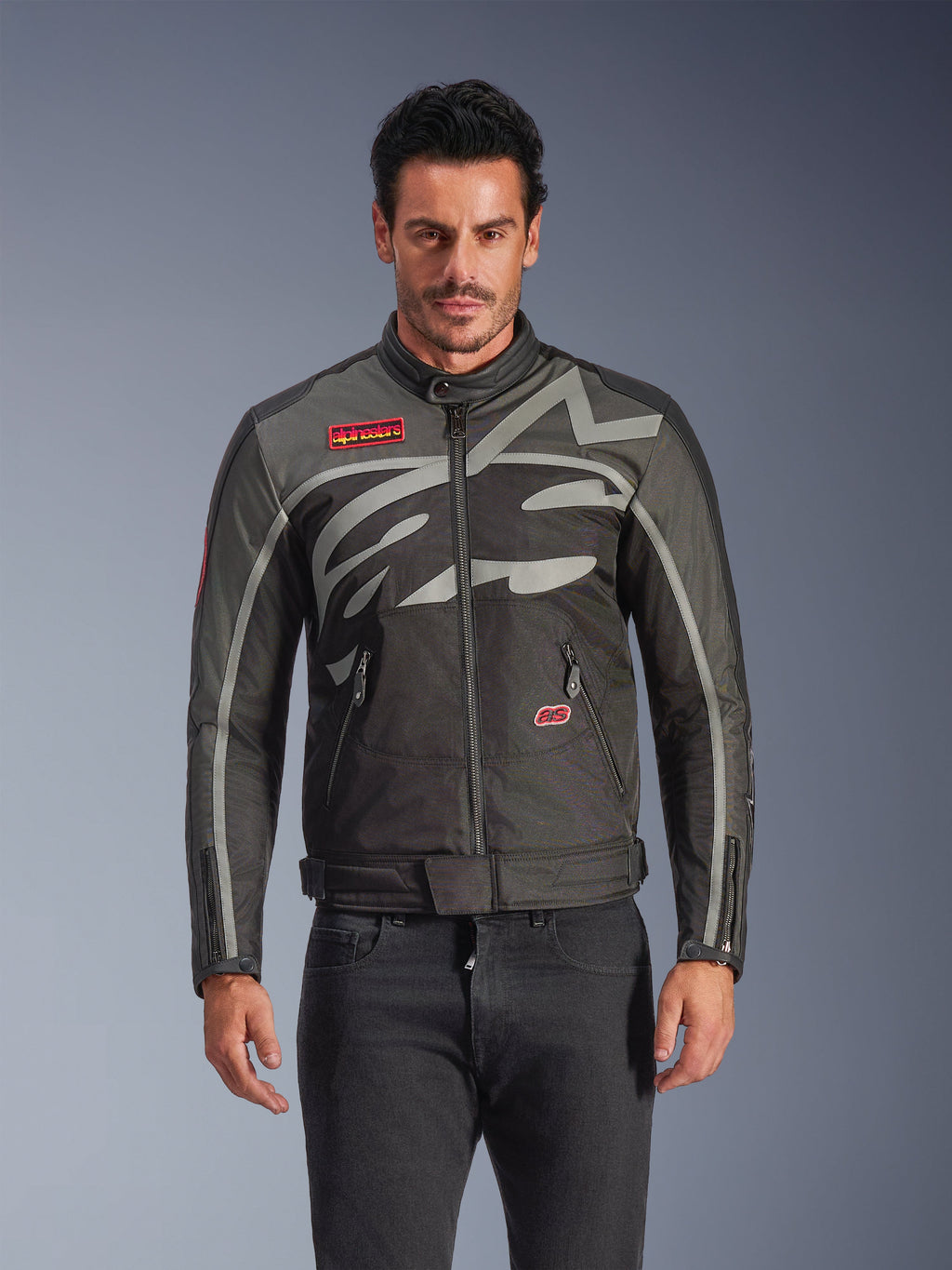 Alpinestars Axton Jacke, Urban-Motorradjacke für Herren, Schwarz und Anthrazit mit roten Akzenten, große umlaufende hellgraue Grafik, rote Logo-Patches auf Brust und Tasche, Frontreißverschluss und Reißverschluss-Manschetten, von Vintage-Rennsport inspiriertes Design für die Straße