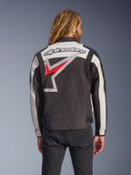 Alpinestars Axton Jacke, Motorradjacke, Schwarz, Off-White und Hellrot, Rückansicht mit großem, umlaufendem Stern-Logo und Wortmarke, von Vintage-Rennsport inspiriertes Design mit Akkordeon-Paneelen an den Schultern und Taillenverstellern