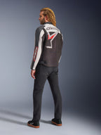 Alpinestars Axton Jacke, Motorradjacke, Schwarz, Off-White und leuchtendes Rot, Rückansicht getragen von einem männlichen Model, mit großem Alpinestars Stern-Logo und Schriftzug auf dem Rücken, Vintage-Rennsport-inspiriertes Design mit Akkordeon-Einsätzen, kombiniert mit schwarzer Hose und Sneakern