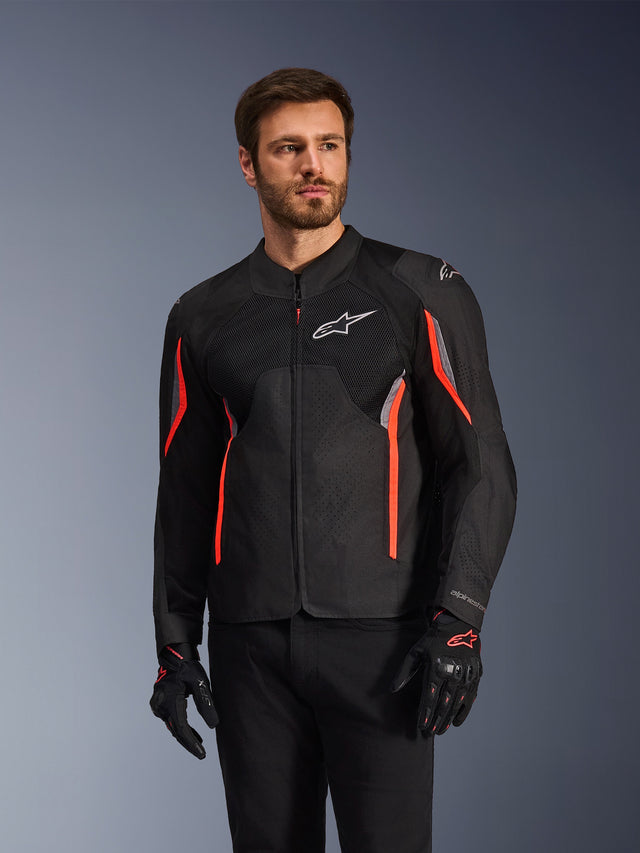 Alpinestars AST V3 Air Jacke, Schwarz, Dunkelgrau und Rot Fluo, getragen von einem Mann mit passenden Handschuhen und schwarzer Hose, mit technischen Mesh-Paneelen, laserperforierten Brustbereichen und leuchtend roten Akzenten, Performance-Sport-Motorradbekleidung