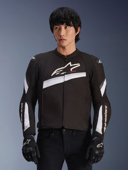 Alpinestars T-GP Plus R V4 Jacket, Black and White, textile motorcycle jacket, featuring white diagonal accents and brand logos on chest and sleeves, worn by a model with black riding gloves, sleek sport-fit design for road riding