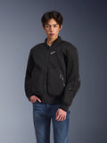 Alpinestars Flight Air Jacke, schwarze Urban-Motorradjacke, getragen von einem Mann mit blauen Jeans, im Bomberjacken-Stil mit Mesh-Einsätzen, Frontreißverschluss und weißem Logo auf der Brust, entwickelt für Stadtfahrten bei heißem Wetter