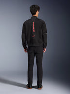 Alpinestars Flight Air Jacke in Schwarz Bright Red, Rückansicht einer urbanen Motorradjacke im Bomber-Stil, mit vertikalem rotem Alpinestars-Schriftzug und Logo auf dem Rücken, leichte 3D-Mesh-Konstruktion, kombiniert mit schwarzer Hose für einen modernen Look.