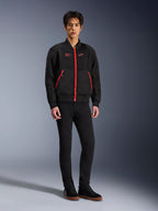 Alpinestars Flight Air Jacke in Black Bright Red, urbane Motorradjacke im Bomber-Stil mit 3D-Mesh-Einsätzen und leuchtend roten Reißverschlüssen, getragen von einem Modell mit schwarzer Slim-Fit-Hose und schwarzen Sneakern, Streetwear-inspirierte moderne Fahrausrüstung
