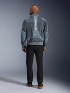 Alpinestars Flight Air Jacke in Storm Gray, Rückansicht eines männlichen Models in einer urbanen Motorradjacke mit 3D-Mesh-Paneelen und vertikalem Alpinestars-Branding, kombiniert mit einer schwarzen Hose für einen modernen Pendler-Look