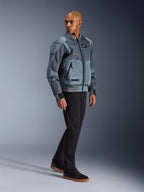 Alpinestars Flight Air Jacke, Storm Gray, urbane Motorradjacke im Bomber-Stil, getragen von einem männlichen Model mit schwarzer Hose und Sneakern, mit großflächigen 3D-Mesh-Belüftungseinsätzen und externen Protektorentaschen, moderne Streetwear-Schutzkleidung für Fahrten bei heißem Wetter