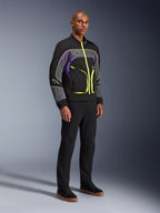 Alpinestars Unite Jacke, urbane Motorradjacke, Black Asphalt Violet mit neongelben Akzenten, getragen von einem Model mit schwarzer Hose und Sneakern, zeitgenössischer Streetwear-Stil für urbane Fahrten
