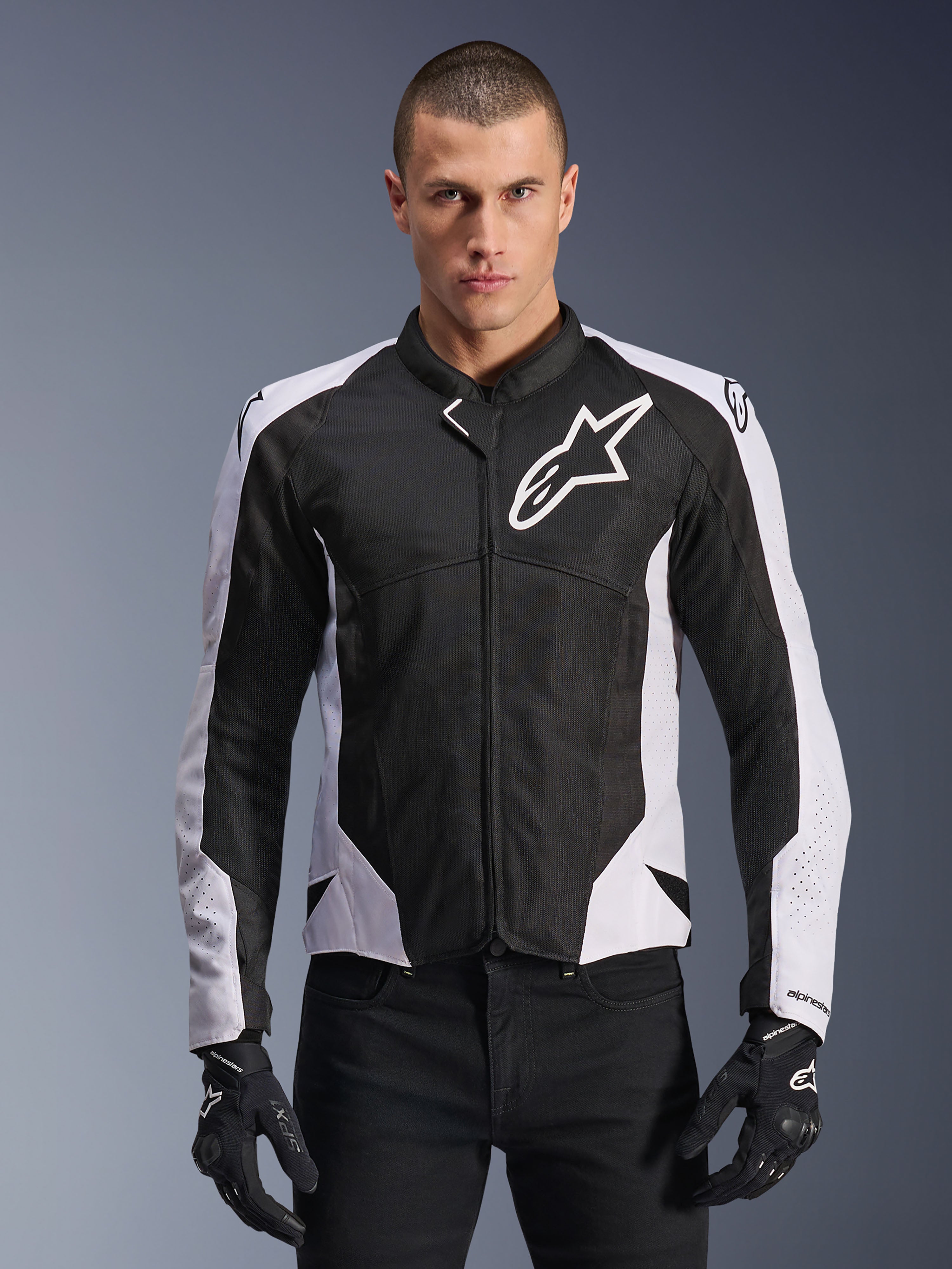 Alpinestars Viper Air V4 Jacke, Motorradjacke, Schwarz und Weiß, am Fahrer getragen, Tech-Mesh- und Textilkonstruktion mit weißen Schulterpanels, markantes Sternlogo auf der Brust, sportliches Performance-Design, kombiniert mit schwarzen Motorradhandschuhen
