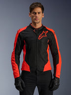 Alpinestars Viper Air V4 Jacket, Motorcycle Racing Jacket, Red Fluo and Black, worn by model with black gloves, tech mesh panels for ventilation, sporty design with Alpinestars star logo on the chest