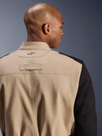 Alpinestars Dice Jacke, urbane Motorradjacke, Hellbraun und Schwarz, Detailansicht des Rückenkragens und der Schulter, mit eingesticktem Logo, robuste Polycotton-Twill-Konstruktion, straßentauglicher Workwear-Stil