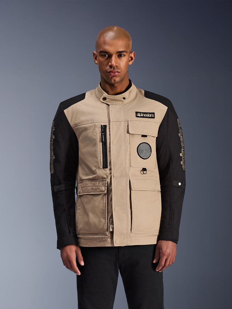 Alpinestars Dice Jacket, Motorradjacke, Beige und Schwarz, mehrere Taschen und Reißverschlüsse, dekorative Patches auf der Brust, hoher Kragen mit Knopfverschluss, moderne Konstruktion