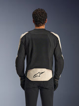 Alpinestars T-SPS Air V2 Jacke, Textil-Motorradjacke, Black Mastic Aluminum, Rückansicht mit großen Mesh-Belüftungspanelen am Rücken, mastic-farbenes unteres Panel mit schwarzem Stern-Logo, getragen mit schwarzer Hose und Handschuhen, sportliches urbanes Design optimiert für Luftzirkulation