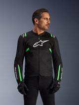 Alpinestars T-SPS Air V2 Jacke, Motorradjacke, Schwarz und Fluo-Grün, getragen von einem Model mit schwarzen Motorradhandschuhen und -hose, weißes Alpinestars-Logo auf der Brust und neongrüne Akzente an Schultern und Ärmeln, Tech-Mesh-Einsätze zur Belüftung, sportlicher Schnitt für urbanes Fahren