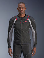 Alpinestars Troop-Air Pro Jacke, Schwarz, Ash Gray und Bright Red, von einem Model getragen, Motorrad-Mesh-Jacke mit perforierten Belüftungspaneelen, roten Reißverschlusstaschen und weißen Schulterlogos, technische gepanzerte Fahrausrüstung
