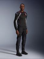 Alpinestars Troop-Air Pro Jacke, Schwarz, Ash Gray und Bright Red, technische Mesh-Protektorenjacke, mit roten Akzenten und weißem Logo auf der Schulter, getragen mit passender schwarzer Hose und Stiefeln, moderne urbane Motorradbekleidung