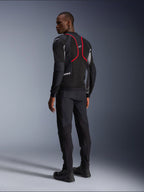 Alpinestars Troop-Air Pro Jacke, Motorradjacke, Schwarz, Eschegrau und Hellrot, Rückansicht am Modell, mit roten Akzentlinien und Mesh-Belüftungseinsätzen, getragen mit schwarzer Hose und Stiefeln, urbaner Motorradstil